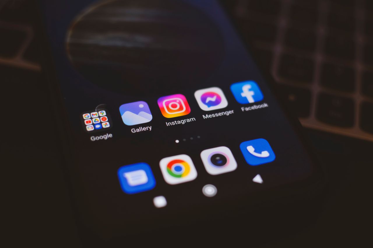 hero-img A smartphone displaying popular social media apps in a dimly lit environment, perfect for tech and communication themes.
